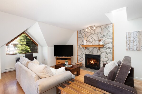Lounge features a comfy couch, futon, presto-log fireplace, and TV