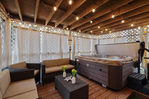This covered area boasts a relaxing hot tub, perfect for unwinding after a long day. The peaceful ambiance created by the soft lighting and protection from the elements makes it a cozy space to rejuvenate. With its serene setting, this covered area with a 