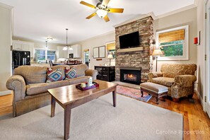 The living room features a stone floor to ceiling gas fireplace with a wall timer