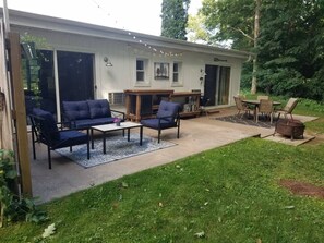 Private outdoor patio with comfortable furnishings, charcoal grill, & table