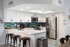 Fully Loaded! Completely remodeled kitchen boasts quartz countertops, beautiful teal glass backsplash, white shaker cabinets, stylish matte black faucet and cabinet pulls,  and all new LG appliances.