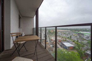 Balcony with a table and chairs offering a scenic city view.
