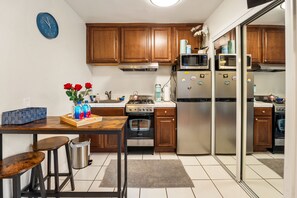 High chair table for two, microwave, fridge, and stove for cooking. 