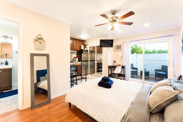 cozy studio with a queen bed, full kitchen and TV.