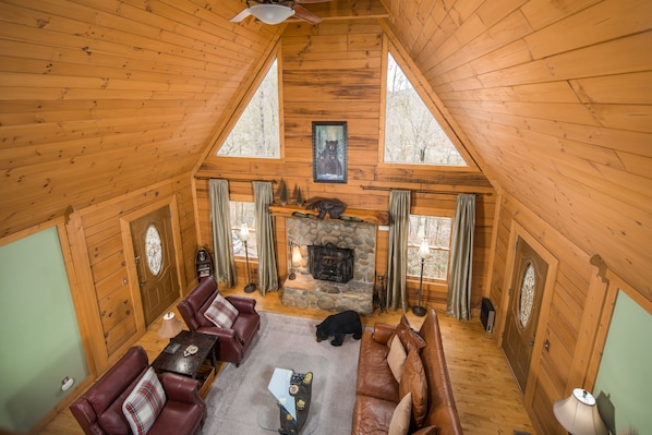 Main level living room with wood burning fire place and flat screen tv.