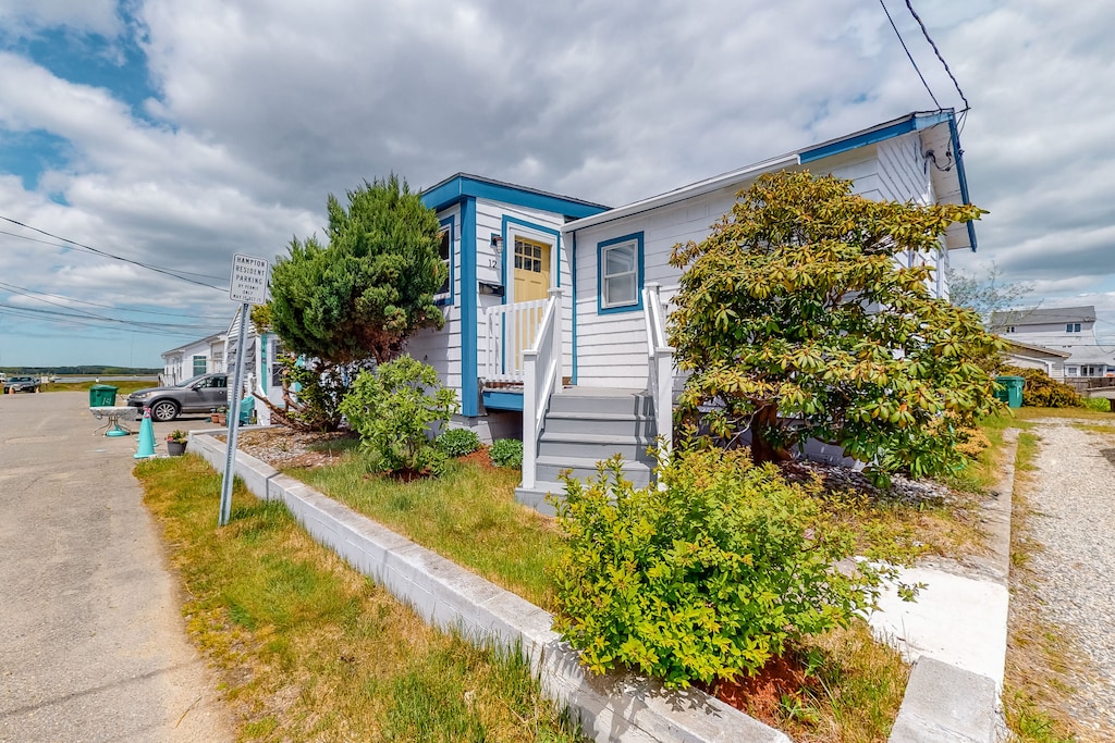 A quaint looking vacation rental near the beach in New Hampshire with trees and shrubbery on the property