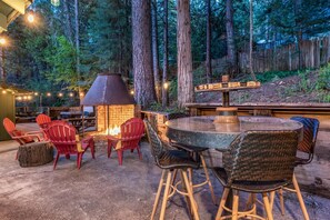 Backyard fit for entertaining with fire pit, sitting area, picnic table, swinging lounge chairs, hot tub, propane BBQ (to the right of table not pictured here).