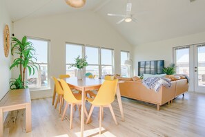 The living & dining area filled with natural light, seating, and a Roku smart TV