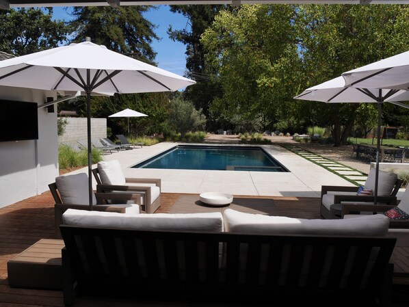 Outdoor living room just off dining area with fully retractable glass wall. 