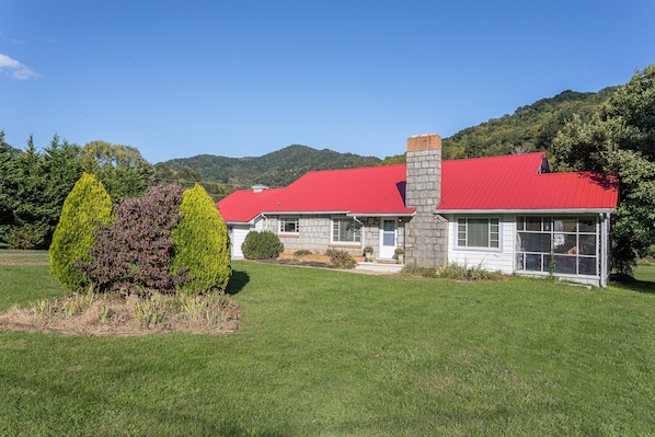 The surrounding mountains provide a beautiful backdrop for the cottage.