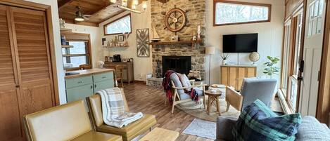 Open layout with vaulted ceilings and a floor to ceiling wood burning fireplace.