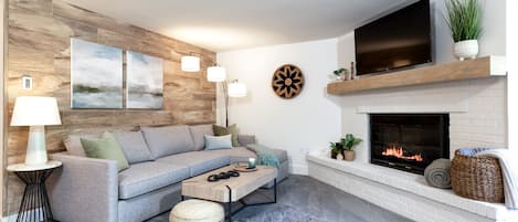 Light, bright living room with a gas fireplace and smart TV to cozy up in. 