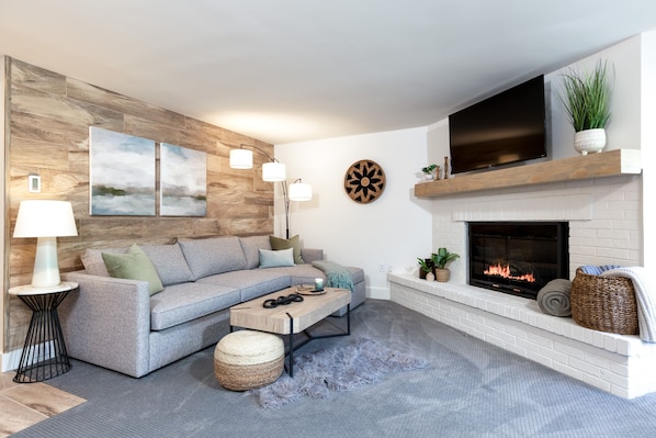 Light, bright living room with a gas fireplace and smart TV to cozy up in. 