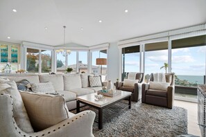 Open concept kitchen  living space with ocean views and sliders opening to decks