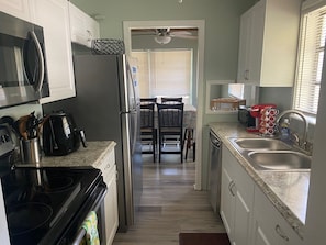 Main house kitchen view stainless steel fridge, stove, microwave, dishwasher