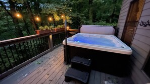6-person hot tub surrounded by Edison lights and in the winter heated walkways
