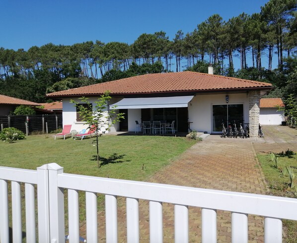 maison indépendante avec son terrain tout clôturé arboré de pins