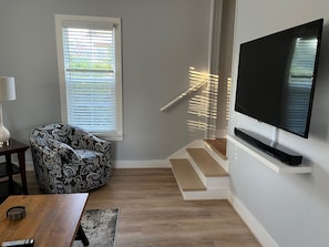 Living room showing staircase to 2nd floor. 