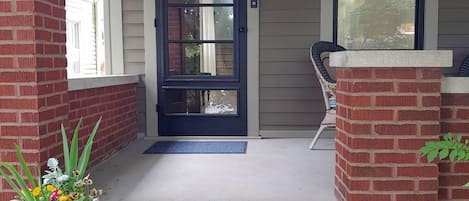 A peaceful front porch with seating for 2.