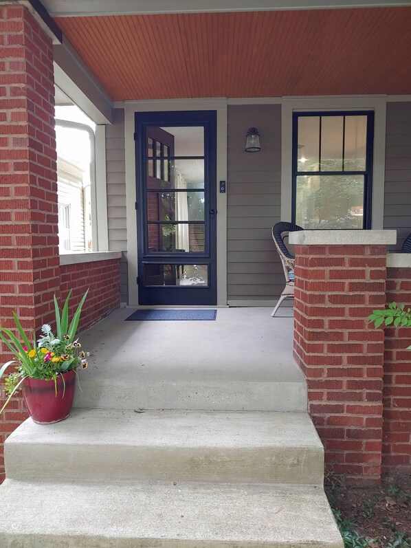 A peaceful front porch with seating for 2.