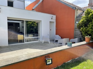 Grande terrasse de 40 m2 avec un coin salon de jardin et un coin repas 