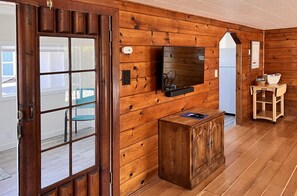 TV with Bose sound bar (blue tooth) with kitchen entrance just beyond.
