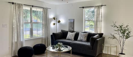 Cozy living room features queen memory foam mattress sleeper sofa & 50" Smart TV