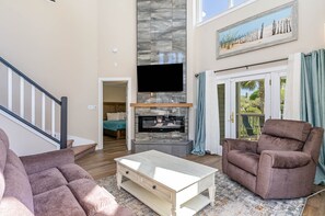 Living Area - The living area features a truly dramatic floor to ceiling fireplace, access to a fantastic screened porch and amazing comfortable furnishings!