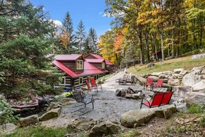 Dramatic setting for a fire surrounded by boulders and sheltered by pines in the yard behind the cabin.  You can see glimpses of the ski slopes - Seven Springs is minutes away!