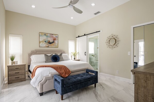 Primary bedroom with en-suite bathroom and pool views. 