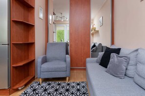 Living room corner featuring a bookshelf, armchair, and a gray sofa for added comfort.
