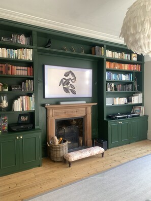 living room full of books, toys and games and a huge TV and sofa for relaxing