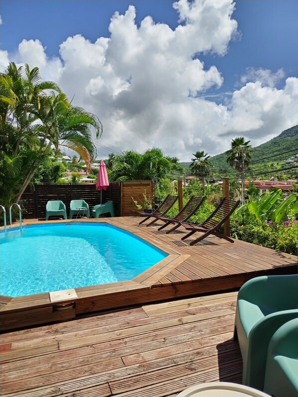 Espace piscine de 80 mètres carrés avec salons de jardin et chiliennes