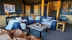 The lower level living room has cozy seating for 8 by the fireplace and 75" TV. 