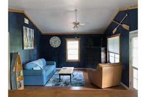 Living room with armoire with board games and TV (difficult to see on top).