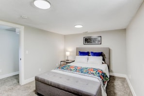Cozy basement bedroom with a queen bed, private entrance, and across the hall from a shared bathroom. Bright and airy room in a quiet neighborhood and just down the hall from the family game room. Sit back, relax, and enjoy the harmonious blend.
