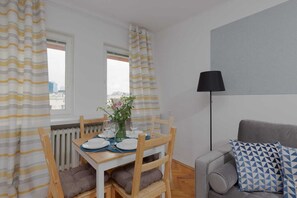 Cozy corner with a small table, lamp, and a view through the window.
