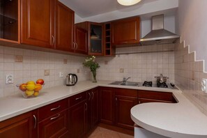 Fully equipped kitchen with dark wooden cabinets, white backsplash, and modern appliances.

