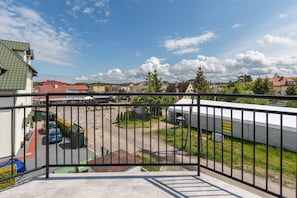 A spacious balcony with outdoor seating, providing a picturesque view of the surrounding neighborhood.