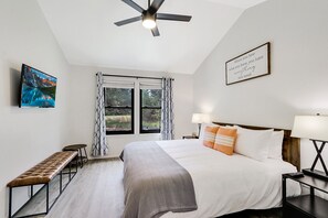 The master bedroom is bright with natural lighting and has a king size bed