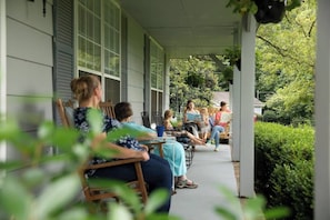 The front porch is our favorite room in the house! There are lots of chairs and a porch swing, all with cushions and pillows of course, which are perfect for a relaxing view of the sunset over the pond.