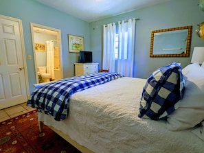 View of the bed, closet, and the entrance to the en-suite bathroom