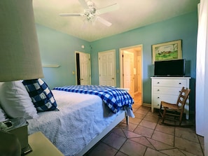 View of the bed, TV, entrance to bathroom, closet and the entrance.