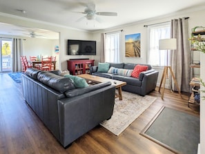 Living room with comfy leather sofas, 55" Roku smart TV, books & games