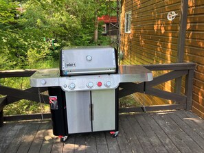 A top-notch propane bbq, with a side burner for outdoor cooking.