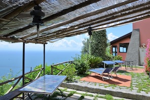 The equipped terrace with the wide pergola on the lower level