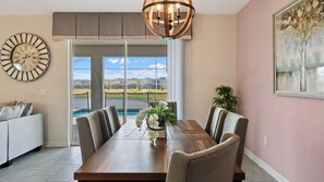 Elegant dining area with pool views, modern decor, and natural light!