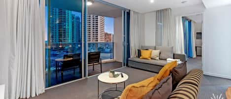 Cozy living room is right next to the balcony overlooking the ocean and the city