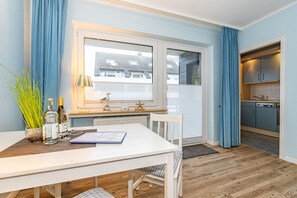 Wohn-/Schlafraum mit Essplatz und Zutritt auf den Balkon