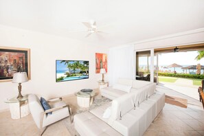 Modern living area with HD television and walkout access to paradise. 